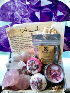 an assortment of bath products sitting on top of a wooden table next to a purple background