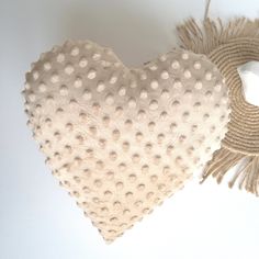 a heart shaped pillow with tassels on it