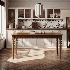 a kitchen with wooden floors and white cabinets, along with a dining room table in the center