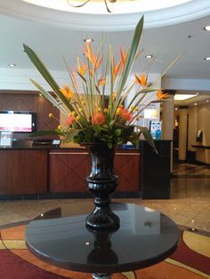 a vase filled with flowers sitting on top of a table in front of a lobby