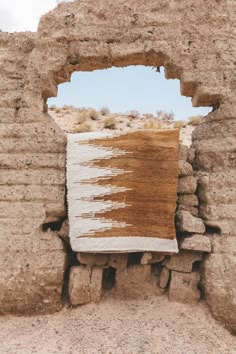 a piece of cloth hanging from the side of a stone wall in an open area