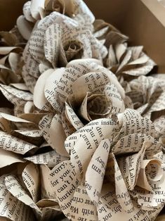 a box filled with lots of old book pages and a flower made out of them