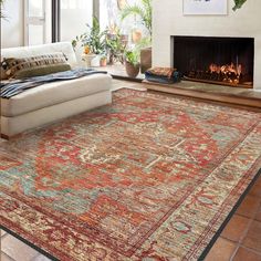 a living room with a large rug on the floor and a fire place in the corner