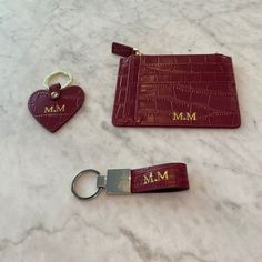 two key chains and a card holder on a marble surface