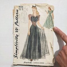 a woman's dress pattern from the 1950's is being held up by her hand