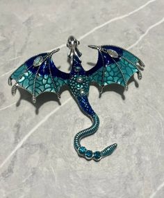 a blue dragon is sitting on top of a marble surface and has its wings spread out