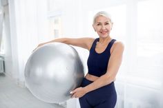 an older woman holding a large metal ball