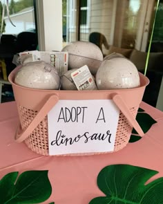 a pink basket filled with lots of balls on top of a table