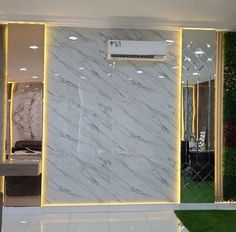 a white marble wall in a store with green plants on the walls and an air conditioner above it