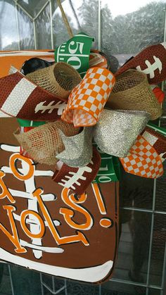 a football themed door hanger hanging from the side of a glass wall with an orange and white banner