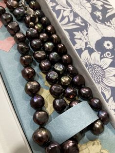 This stunning necklace is a unique piece of jewelry that will make you feel elegant and sophisticated. It features natural freshwater black peacock pearls, which are dyed with an organic dye to create a beautiful range of colors, such as green, purple, blue, grey, silver, or peacock.  The pearls are 8 mm in diameter and have a baroque shape, which adds character and charm to the necklace.  The necklace is 26 inches long and has a handmade knot between each pearl, which prevents them from rubbing against each other and ensures durability.  The necklace has a sterling silver clasp, which is easy to use and secure, and it adds a touch of elegance to the necklace. The necklace comes with a unique handmade packaging designed specifically for this item. This necklace is perfect for anyone who lo Baroque Pearl Jewelry, Baroque Pearls Jewelry, Black Peacock, Peacock Pearls, Peacock Pearl, Beautiful Range, Handmade Packaging, Organic Dyes, Stunning Necklace