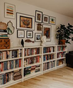 a bookshelf filled with lots of books next to a couch