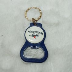 a blue and white keychain with a michigan love bottle on the front that says,