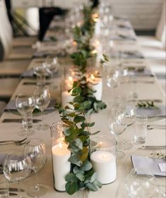 a long table with candles and greenery on it