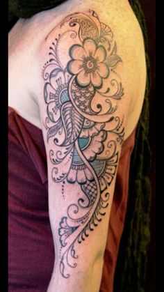 a woman's arm with an intricate tattoo design on her left arm and shoulder