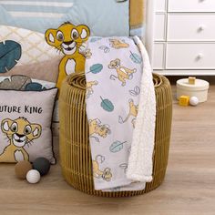 a basket filled with baby blankets next to a stuffed animal and other items on the floor