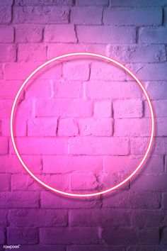 a neon pink circle on a brick wall with the light reflecting off it's side