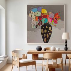 a dining room table with chairs and a painting on the wall