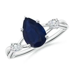 an oval shaped blue sapphire and diamond ring with three diamonds on the shoulders, set in white gold