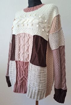 the sweater is knitted in different colors and patterns, including brown, pink, white, and beige