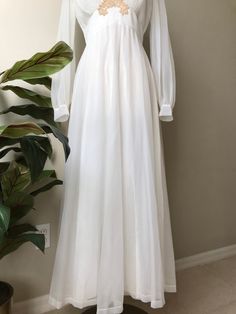 "ON SALE 1940s White chiffon maxi dress Lined in acetate, zips at back V neckline with chantilly lace Zips at back No tags, looks custom made by seamstress Long sleeves are sheer *Needs dry cleaning to lighten the lace that has yellowed over the years Bust 18\" across Waist 14\" across Length 56\" Shoulders 15\" seam to seam Sleeves 19\" from armpit *Brooch not included" Chiffon Maxi Dress With Sheer Sleeves For Wedding, Flowy Vintage Maxi Dress For Wedding, Sheer Flowy Maxi Dress For Wedding, Sheer Chiffon Maxi Dress For Wedding, Wedding Sheer Chiffon Maxi Dress, Fitted Vintage Chiffon Maxi Dress, Elegant Sheer Vintage Dress For Wedding, Elegant Sheer Vintage Wedding Dress, Vintage Dresses 1940s