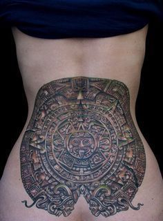 a woman's stomach with an intricate tattoo on it