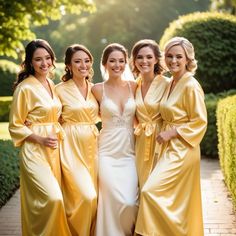 four bridesmaids in yellow robes pose for a photo outside on a brick path