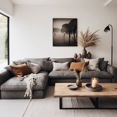 a living room with couches, tables and pictures hanging on the wall above them