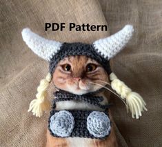 a cat wearing a knitted hat and scarf with horns on it's head