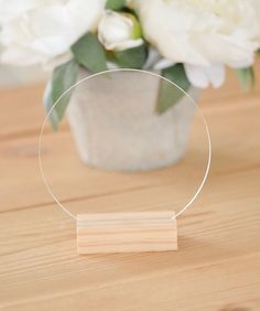 a vase with flowers in it sitting on a table next to a piece of wood