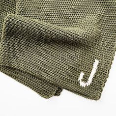 a green knitted beanie with the letter j on it