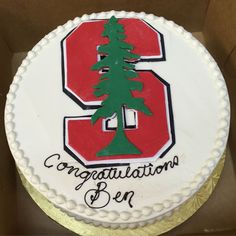 a cake in a box with the number 3 on it and a pine tree on top