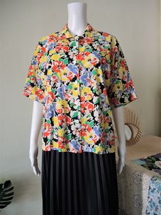 Beautiful Vintage short sleeve blouse from the 1980s. Comfortable cotton fabric with a vibrant summer floral pattern. Straight, boxy cut, wide sleeves, button down. Looks great with a pair of jeans and flatform sandals. BRAND: C&A ERA: 1980s COLOR: White, black, green, yellow, red, lilac FABRIC: 100% cotton SIZE: No size tag, fits best size M to small L (or S for a more oversized fit) - please check measurements below for reference MEASUREMENTS: Pit to pit 54cm, total length 60cm CONDITION: Multicolor Floral Print Short Sleeve Shirt For Summer, Summer Multicolor Floral Print Short Sleeve Shirt, Multicolor Hawaiian Shirt For Spring, Multicolor Floral Print Short Sleeve Shirt For Spring, Multicolor Floral Print Short Sleeve Shirt, Multicolor Collared Hawaiian Shirt For Spring, Spring Multicolor Collared Hawaiian Shirt, Retro Multicolor Short Sleeve Shirt For Spring, Summer Short Sleeve Hawaiian Shirt For Spring