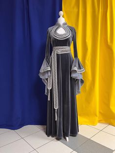 The dress is made from artificial velvet in gray color. Sleeves and a belt are decorated with the wide silver knitted and woven braid. The main decoration of a dress is sleeves which beautifully fall down and have the real elfin appearance. There aren't any fasteners on the dress, thanks to ability of fabric it is good to stretch. The suit consists of a dress and a belt. Material: velvet. The dress can be made in any size. Production of a dress takes 7-10 working days. Winter Medieval Dress, Medieval Long Sleeve Party Dress, Elegant Long Sleeve Medieval Dress For Fancy Dress, Fantasy Style Floor-length Wedding Dress, Elegant Fitted Velvet Costume Dress, Fantasy Floor-length Wedding Dress, Elegant Fitted Velvet Dress For Costume, Fantasy Floor-length Dress For Cosplay, Elegant Floor-length Medieval Dress For Festivals