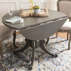 a dining room table with two chairs and a wine bottle on top of the table