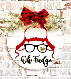 a sign that says, oh fuge with glasses and a bow on it in front of a brick wall