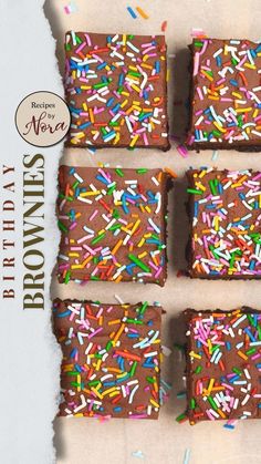 four brownies with sprinkles are on a piece of parchment paper that has been cut into squares