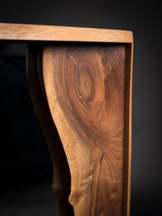 a close up of a piece of wood on a black background with an object in the middle