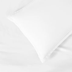 two white pillows sitting on top of a bed