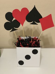 a white box filled with black and red paper hearts