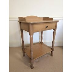 a small wooden table with two drawers on one side and an open drawer on the other