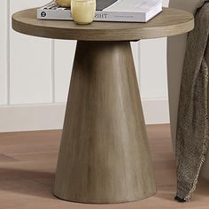 a table with a book and candle on it next to a chair in a room