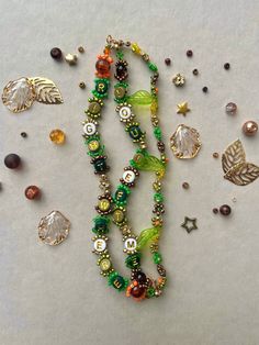 several different types of beads and charms on a white surface with one bead in the middle