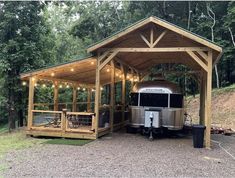 a trailer parked in front of a wooden structure with lights on the roof and windows