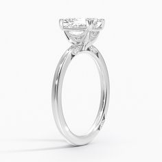 a white gold engagement ring with an oval shaped center stone and side stones on the sides