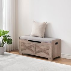 a wooden bench sitting next to a window with a plant in the corner and a white rug on the floor