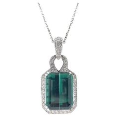 Introducing an exquisite fusion of elegance and natural splendor: our breathtaking 12.86 carat Green Emerald Pendant adorned with 65 round diamonds totaling 0.50 carats, all set in luminous 14k white gold. At the heart of this pendant lies a magnificent 12.86 carat Green Emerald, radiating with the lush hues of nature's finest foliage. Renowned for its rich color and captivating allure, the emerald exudes an aura of opulence and refinement. Surrounding the emerald are 65 round diamonds, meticulously set in a halo design, enhancing the beauty of the emerald with their brilliant sparkle. With a total weight of 0.50 carats, these diamonds add an extra touch of glamour and sophistication to the pendant. Green Pendant, Green Pendants, Halo Design, Emerald Pendant, Green Emerald, Emerald Diamond, Diamond Pendant, Emerald Green, Rich Color