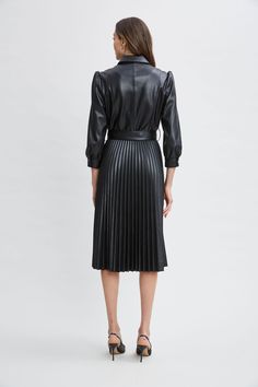 Meet our modern, endlessly versatile Vegan Leather Shirtdress that's infused with an edgy feminine vibe. The sporty shirt-dress silhouette, self-belt & pleated midi skirt give it the cool factor you want for easy Fall days. Dress it up with heels or down with sneakers- effortlessly chic either way. T-Tahari Vegan Leather Long Sleeve Belted Pleated Midi Dress 100% Polyurethane Runs true to Size Model is 5'9" and wearing size S Dry Clean Only Imported Style #: THF49028 Chic Knee-length Belted Dress For Fall, Chic Collared Fitted Belted Dress, Chic Collared Belted Fitted Dress, Chic Fitted Collared Belted Dress, Fall Belted Dress For Date Night, Fall Date Night Belted Dress, Black Belted Dress For Office In Spring, Black Belted Dress For Office And Spring, Chic Fall Midi Dress With Fitted Waist