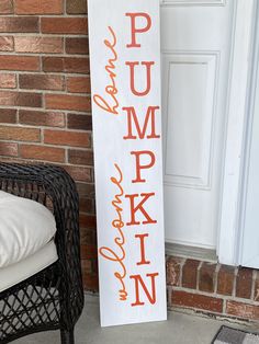 a wooden sign that says pumpkin and is next to a wicker chair on the porch