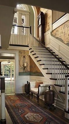 a staircase leading up to a living room and dining room area with chandelier